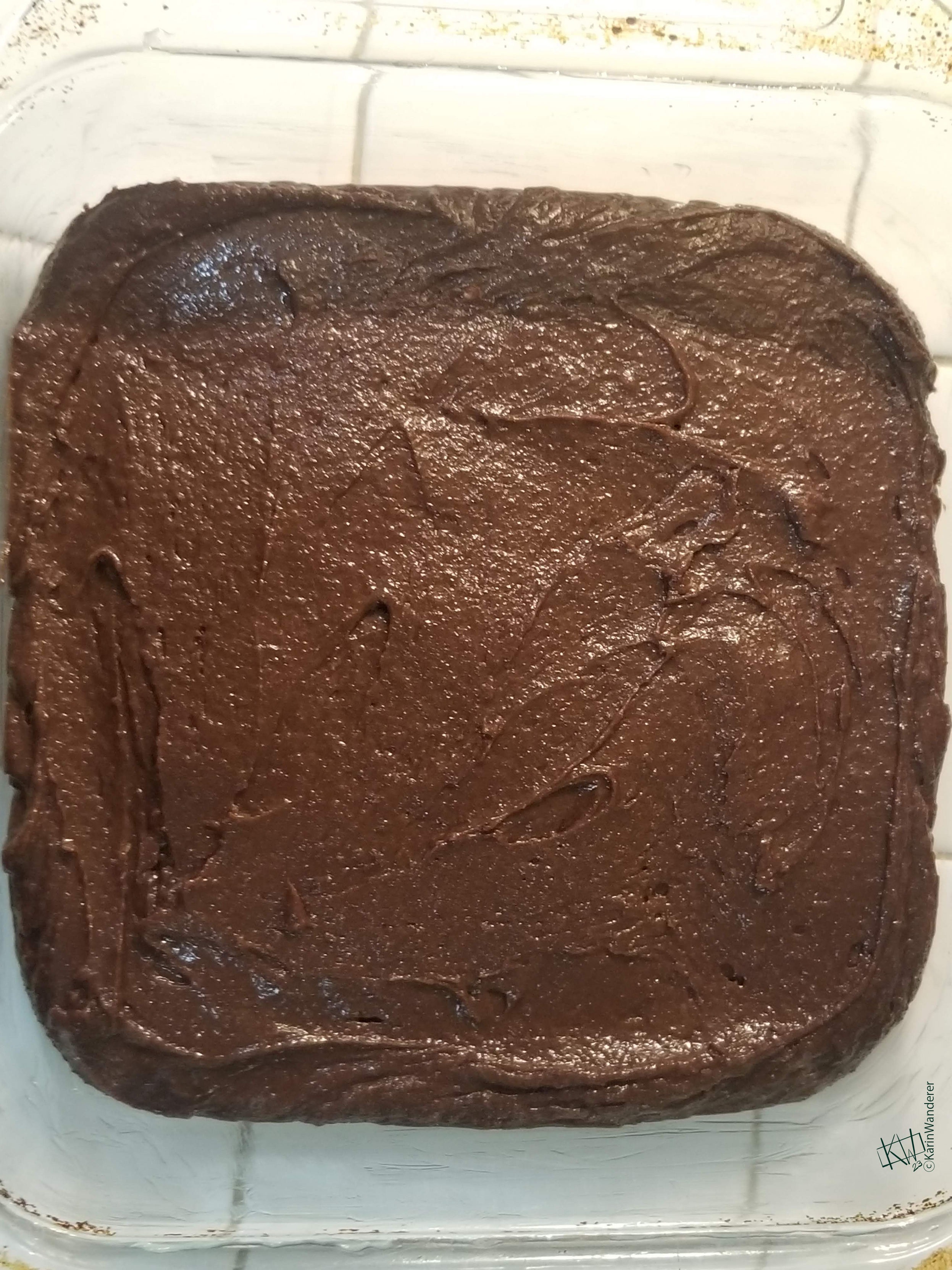 Photo of brownie batter in a square glass baking dish.