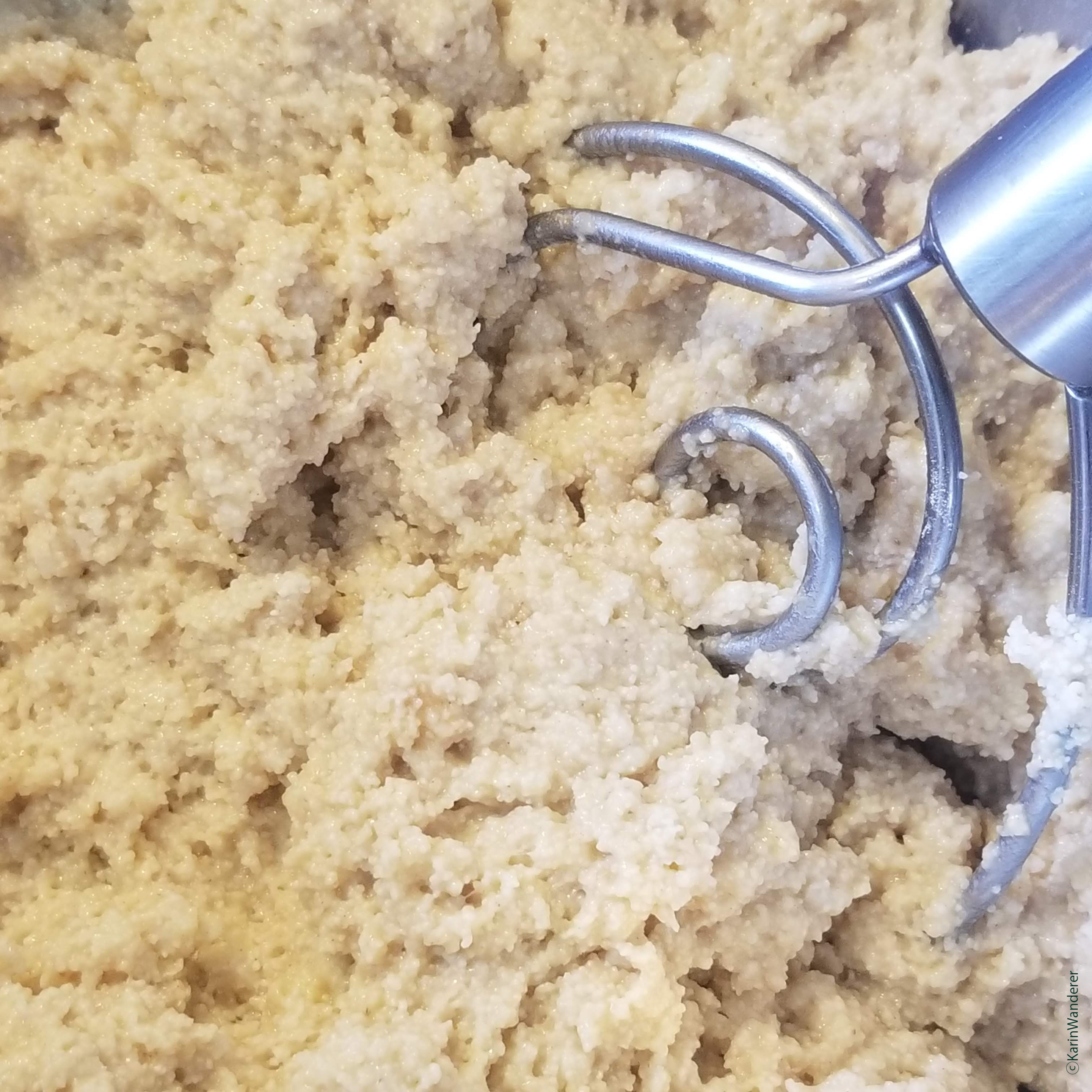 Photo of just-mixed bread dough; it almost looks like very wet sand.
