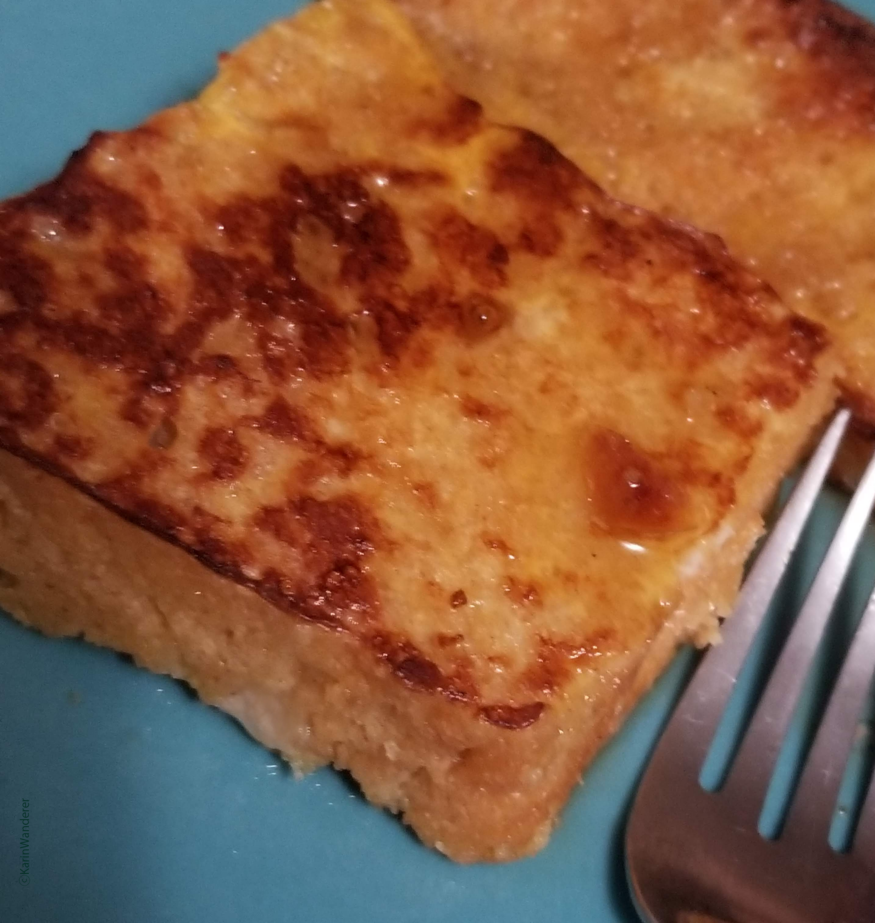 A slice of delicious peanut butter bread french toast with maple syrup.