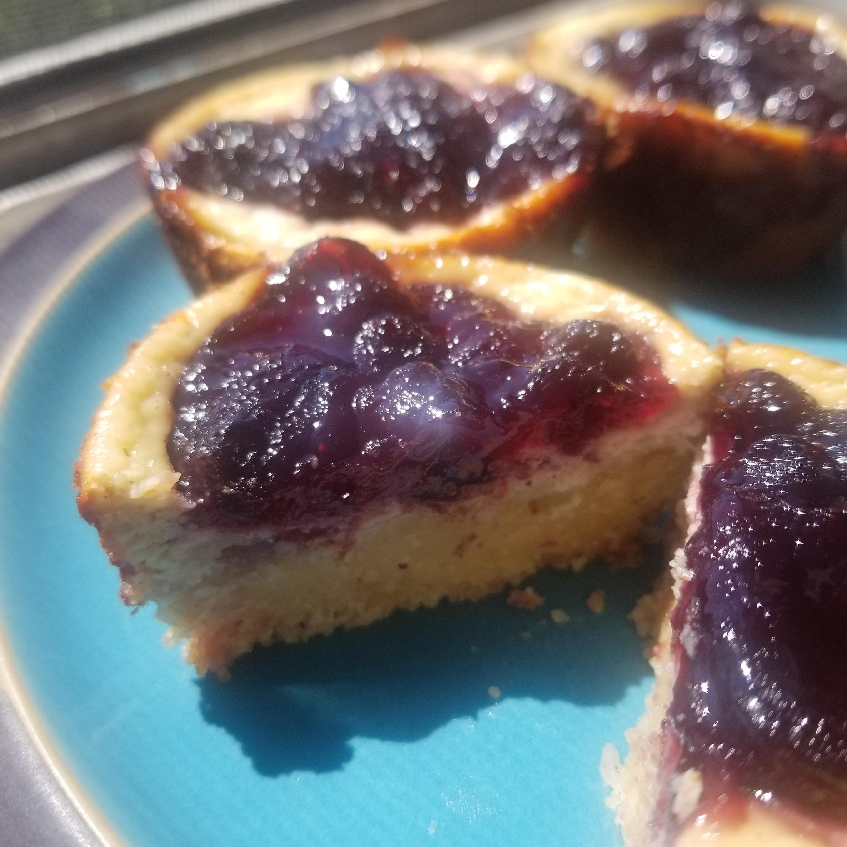 Photo of beautiful blueberry tarts, with one cut open to show the delicious center.