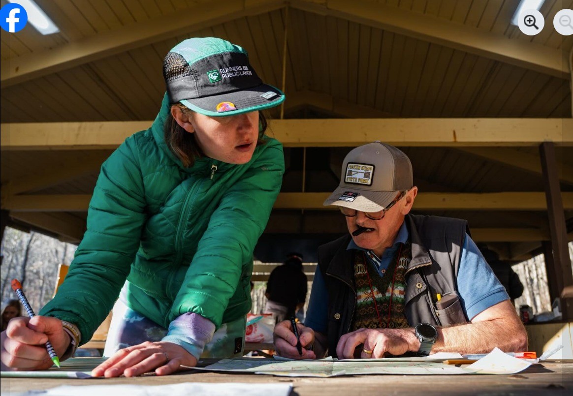 2 different runners study their maps